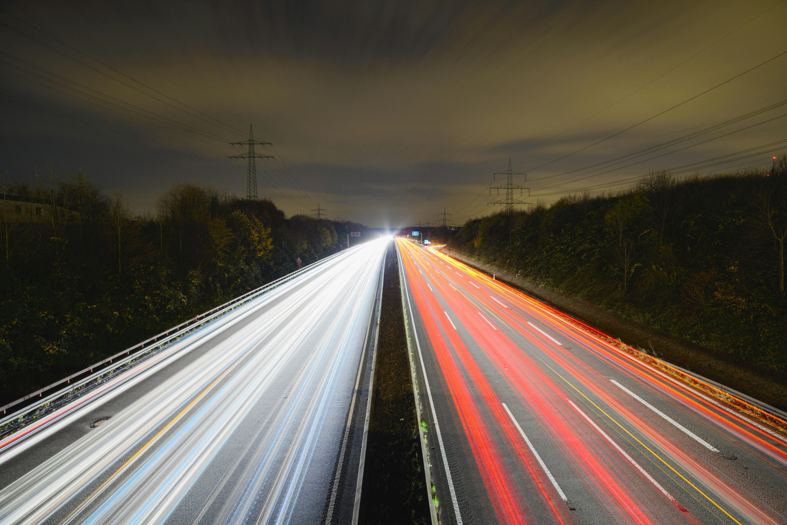 Captivating long exposure photo showcasing dynamic light trails on a nighttime highway.